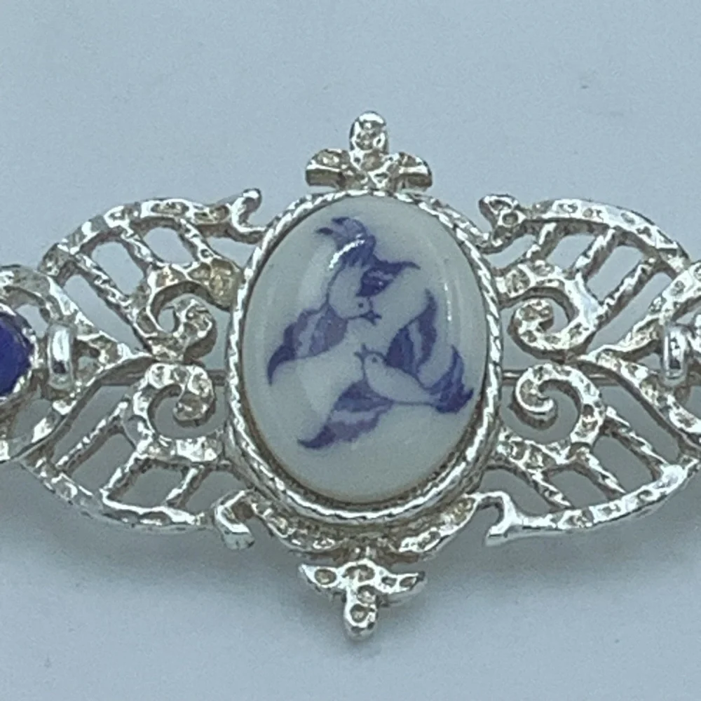 Silver-Tone Filigree Brooch with Blue/White Bird Design